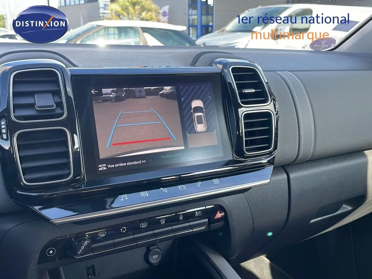 Vue rapprochée de la console centrale du Citroën C5 Aircross blanc nacré, avec écran tactile affichant la caméra de recul.
