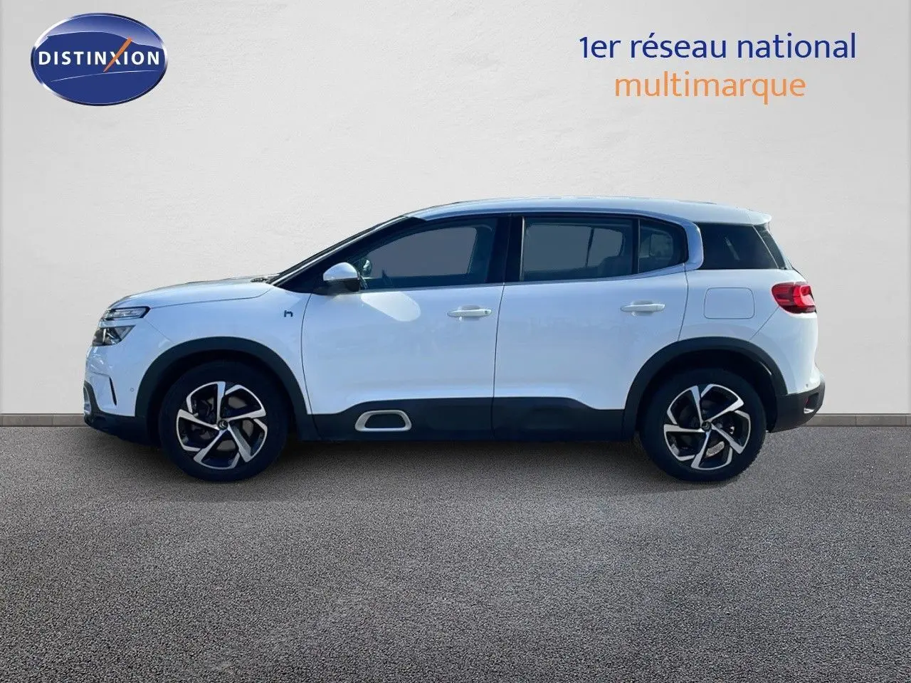 Profil droit d'un Citroën C5 Aircross blanc nacré avec jantes bi-ton et protections noires sur bas de caisse.