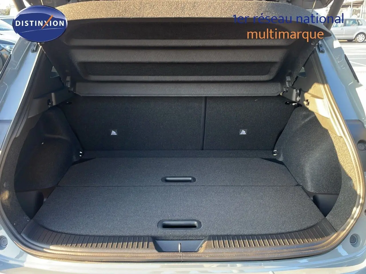 Coffre ouvert du Nissan Qashqai 2025 gris céramique métal, vue arrière montrant un espace de chargement plat et spacieux.