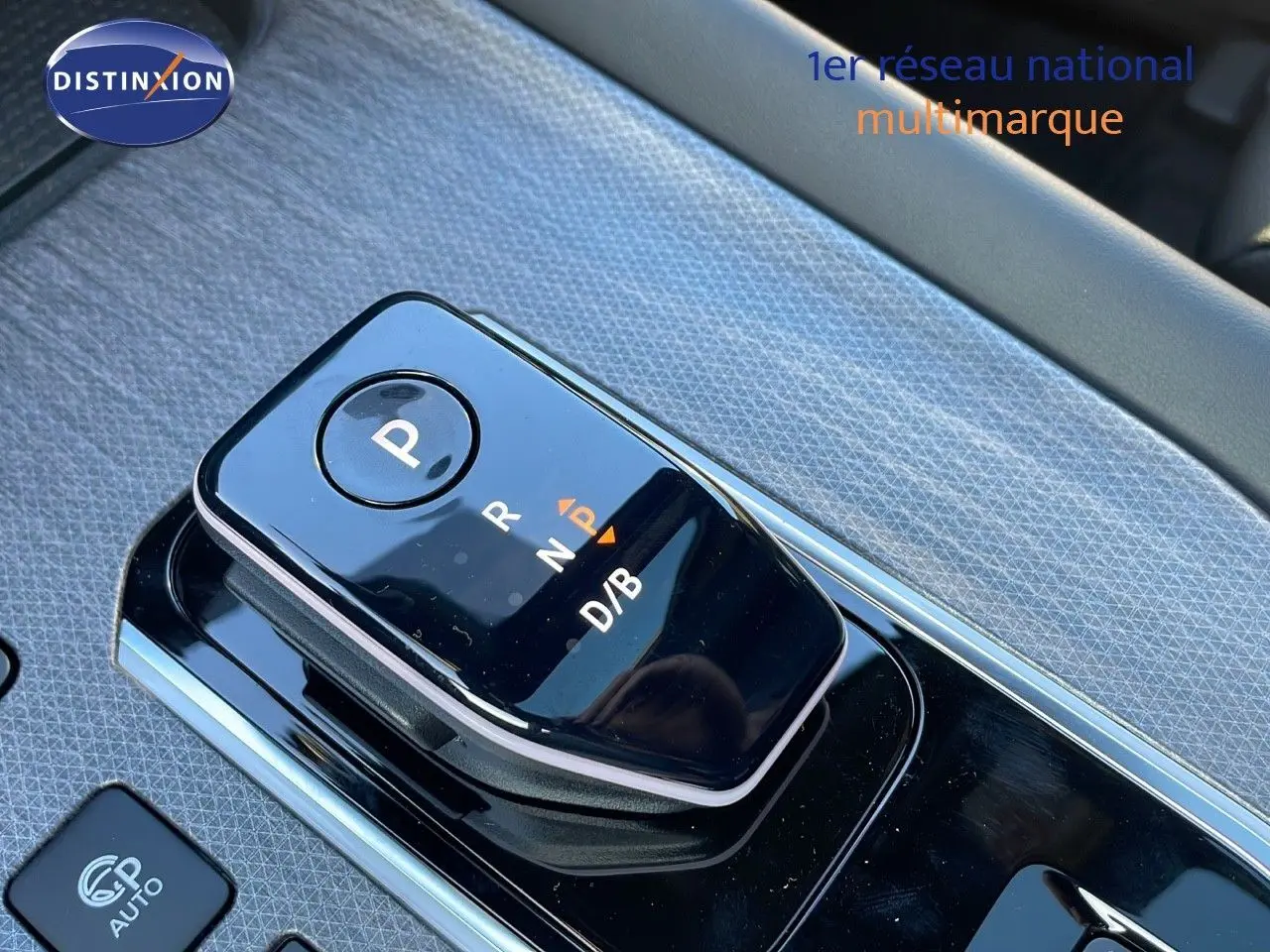 Gros plan sur la commande de boîte automatique noire du Nissan Qashqai gris céramique, avec levier de vitesses et mode D/B.