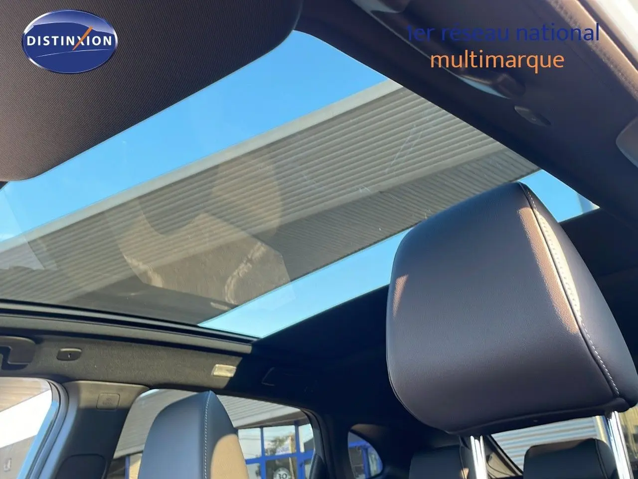 Vue intérieure du Nissan Qashqai 2025 avec toit panoramique et sièges en cuir noir visibles côté droit.