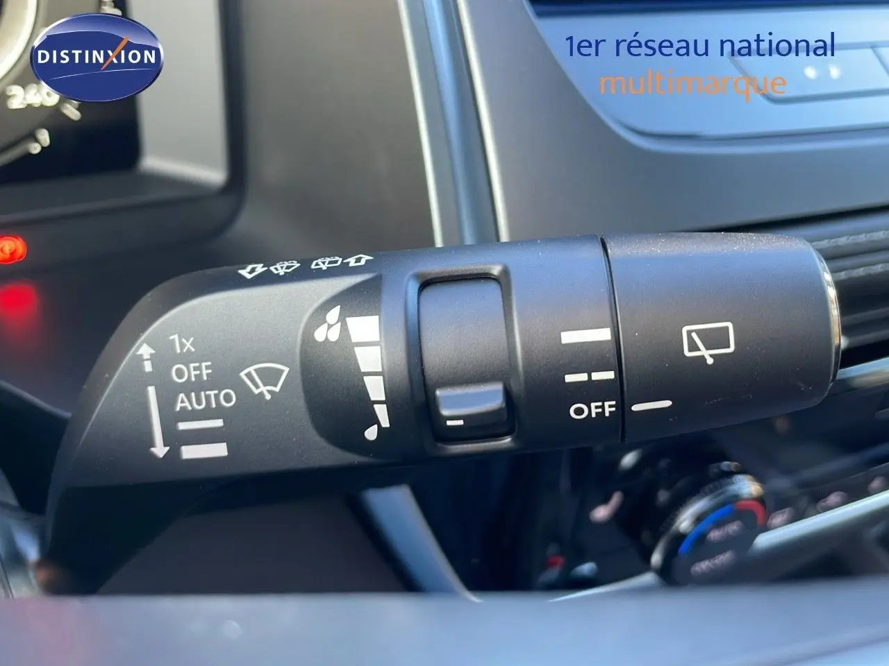 Gros plan sur la commande d’essuie-glace du Nissan Qashqai 2025 gris céramique, avec tableau de bord en arrière-plan.