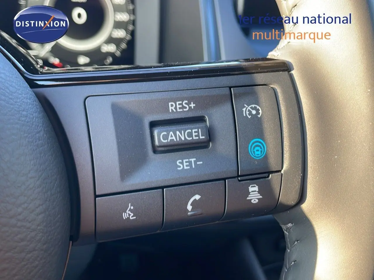 Gros plan sur les commandes de régulateur de vitesse au volant d'un Nissan Qashqai 2025 en gris céramique métal.