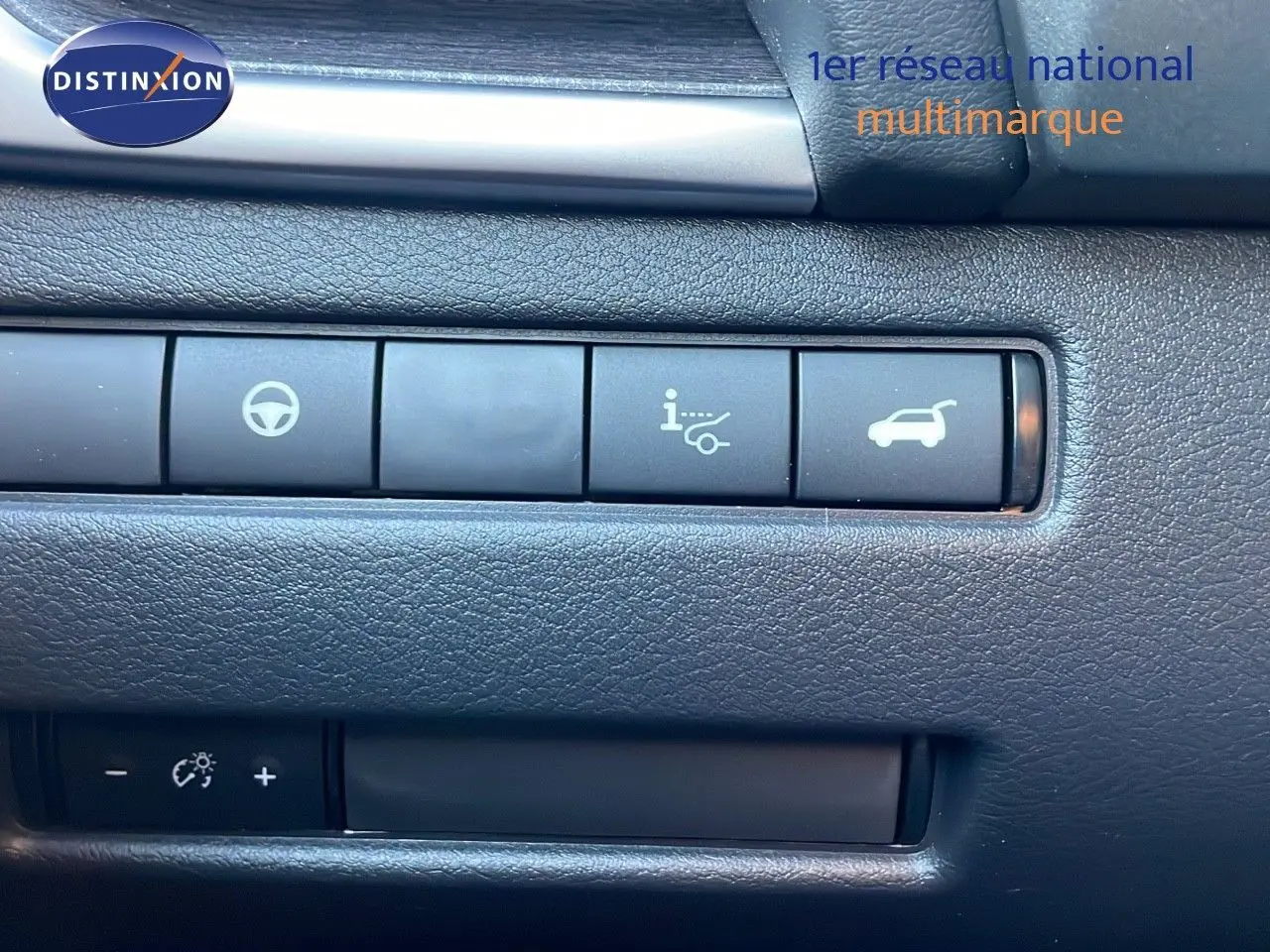 Boutons de commande sur tableau de bord intérieur du Nissan Qashqai 2025 gris céramique métal, avec icônes de direction et coffre.