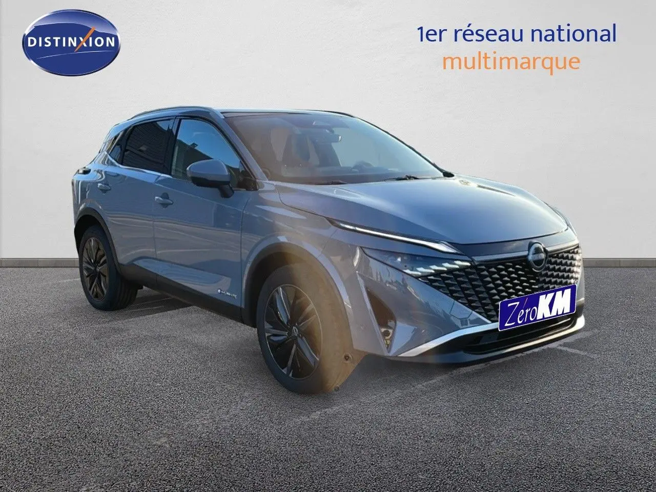 Nissan Qashqai gris céramique métal en 3/4 avant droit, avec calandre noire et jantes bi-ton.