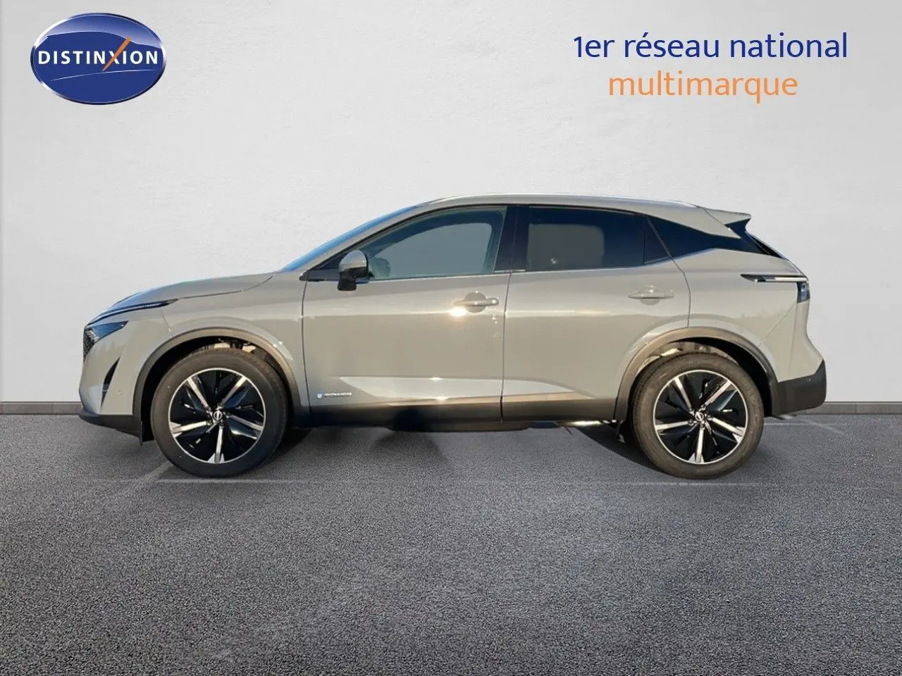 Profil côté gauche du Nissan Qashqai 2025 gris céramique métal avec jantes noires bicolores et toit noir contrasté.