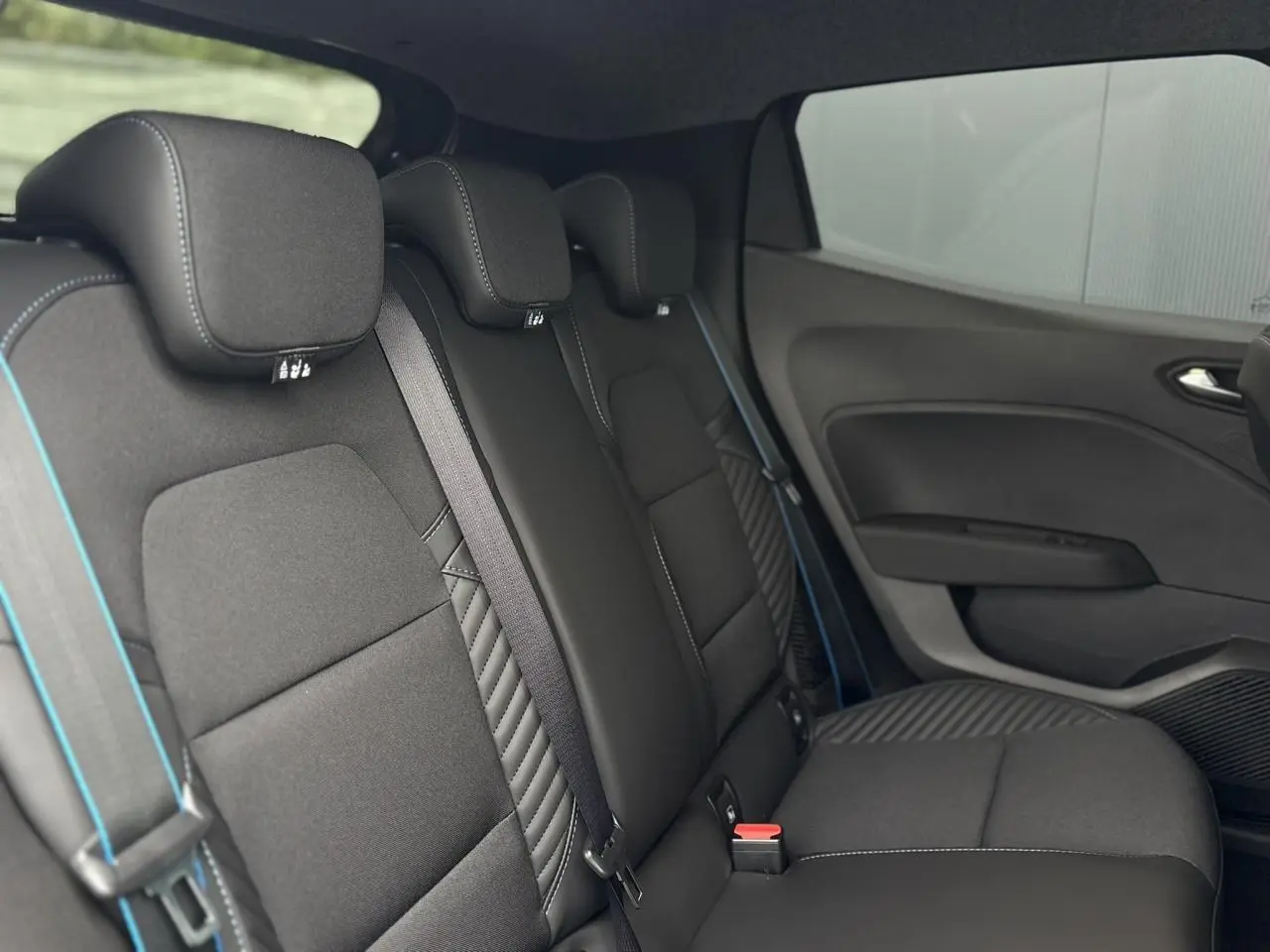 Vue intérieure côté droit des sièges arrière noirs avec surpiqûres bleues et ceintures assorties de la Renault Clio Esprit Alpine 2025.