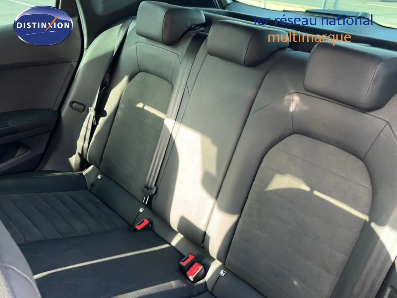 Vue intérieure montrant la banquette arrière en tissu noir du SEAT Arona 2025, avec ceintures de sécurité et appuie-têtes.