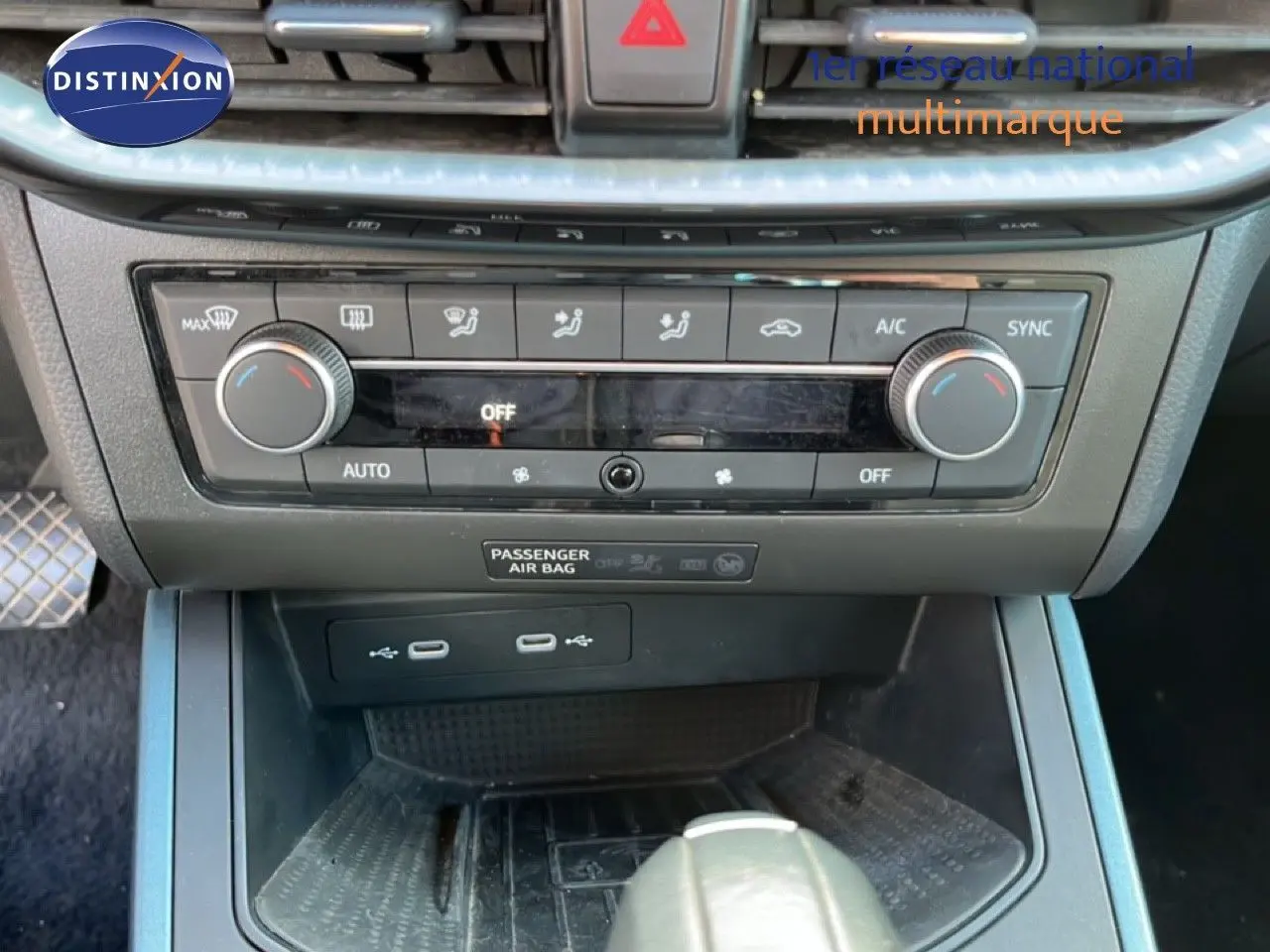 Vue rapprochée du tableau de bord et console centrale du SEAT Arona gris, montrant les commandes de climatisation et ports USB.