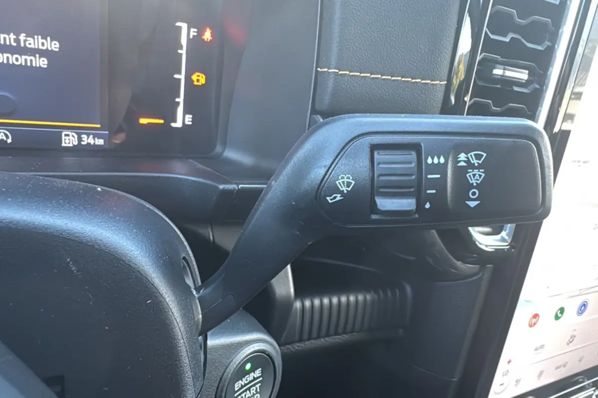Gros plan sur la commande d’essuie-glace à gauche du volant dans l’habitacle noir du Ford Ranger gris carbone 2026.