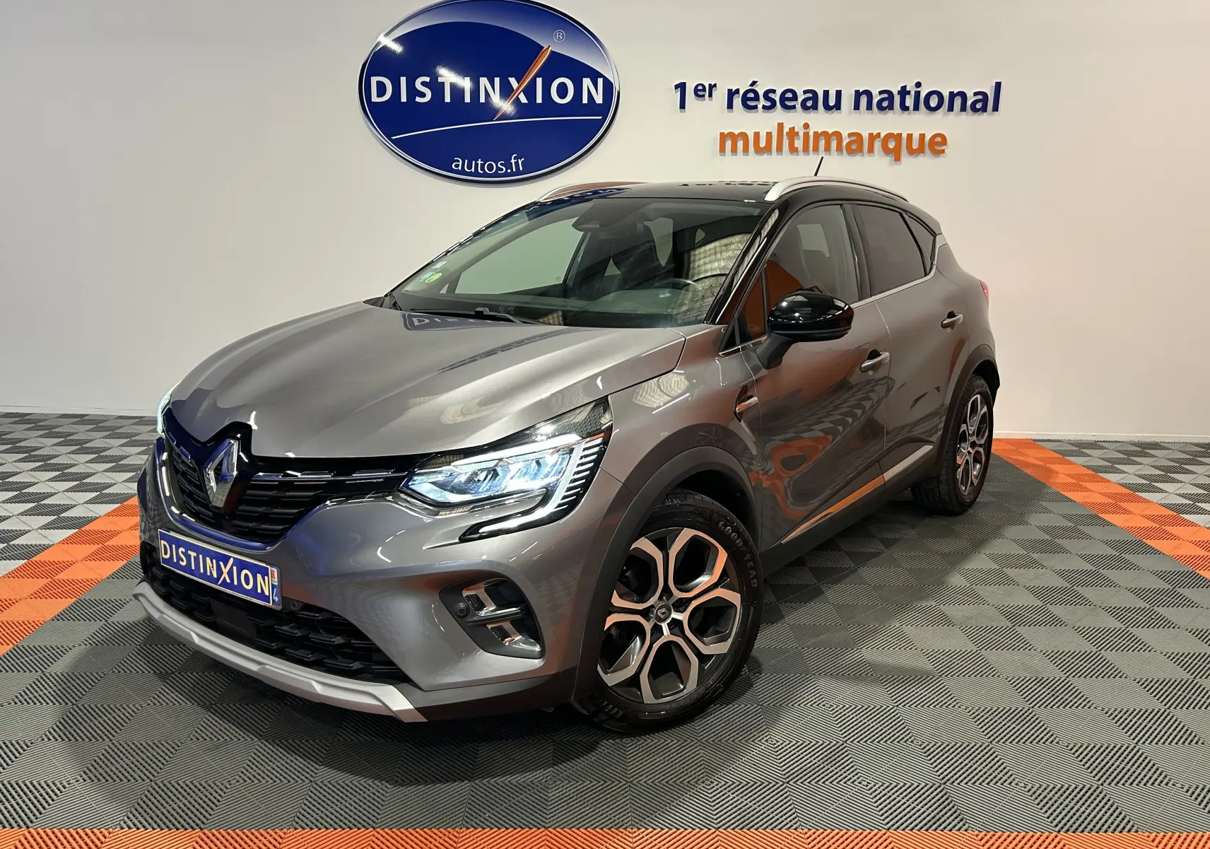 Renault Captur gris en 3/4 avant droit, avec phares LED allumés et jantes alliage distinctives.