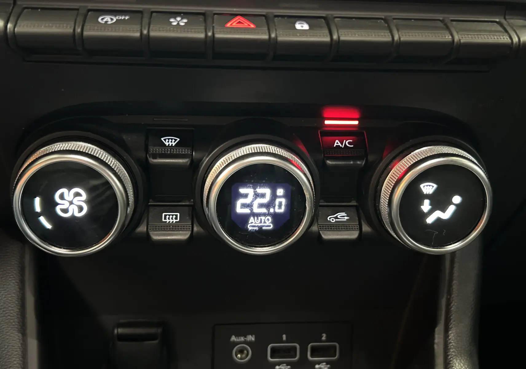 Gros plan sur les commandes de climatisation du Renault Captur gris 2020, avec affichage digital à 22°C et bouton A/C allumé.
