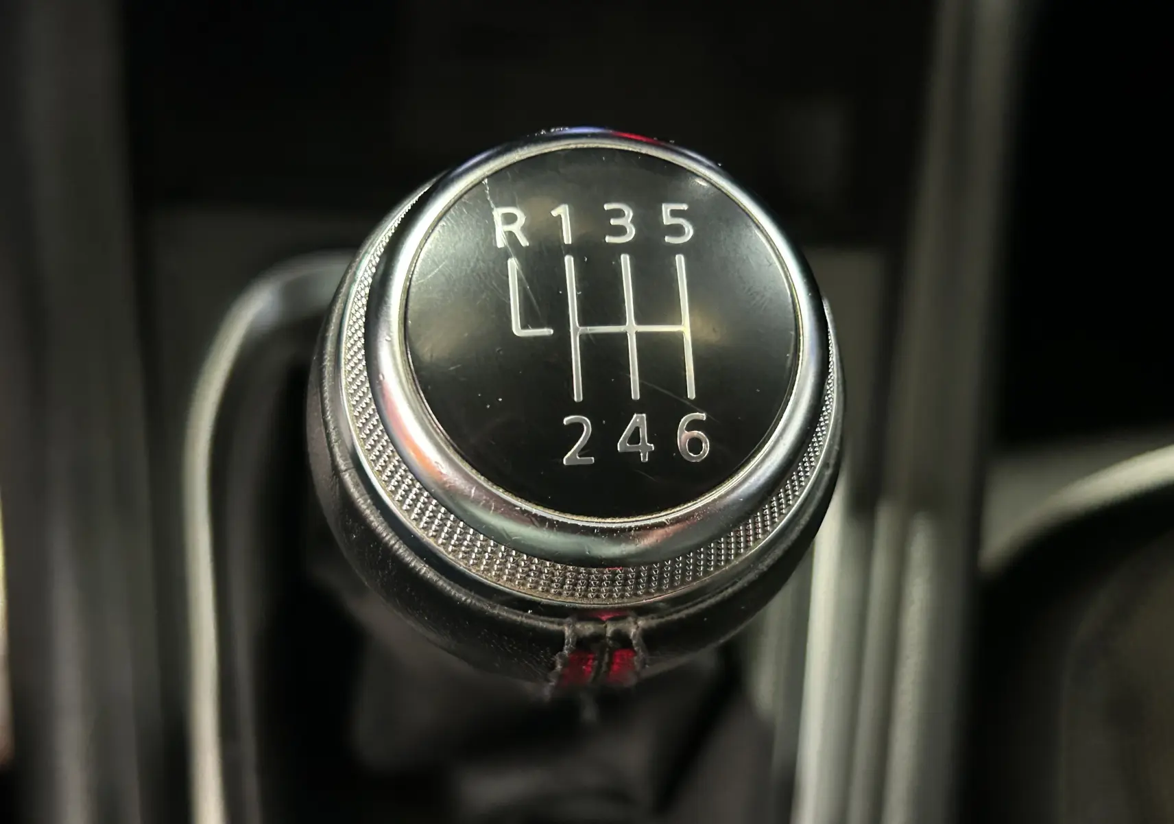 Gros plan sur le pommeau de la boîte manuelle noire du Renault Captur 2020, avec marquage des vitesses en blanc.