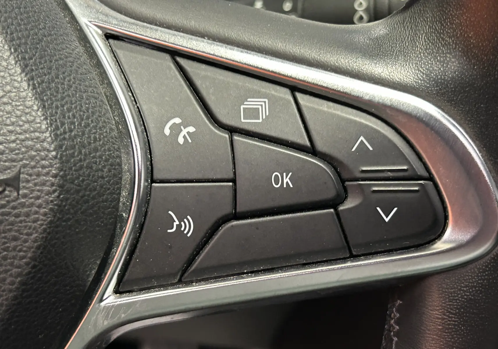 Gros plan sur les commandes multifonctions noires à droite du volant du Renault Captur gris, version 2020.