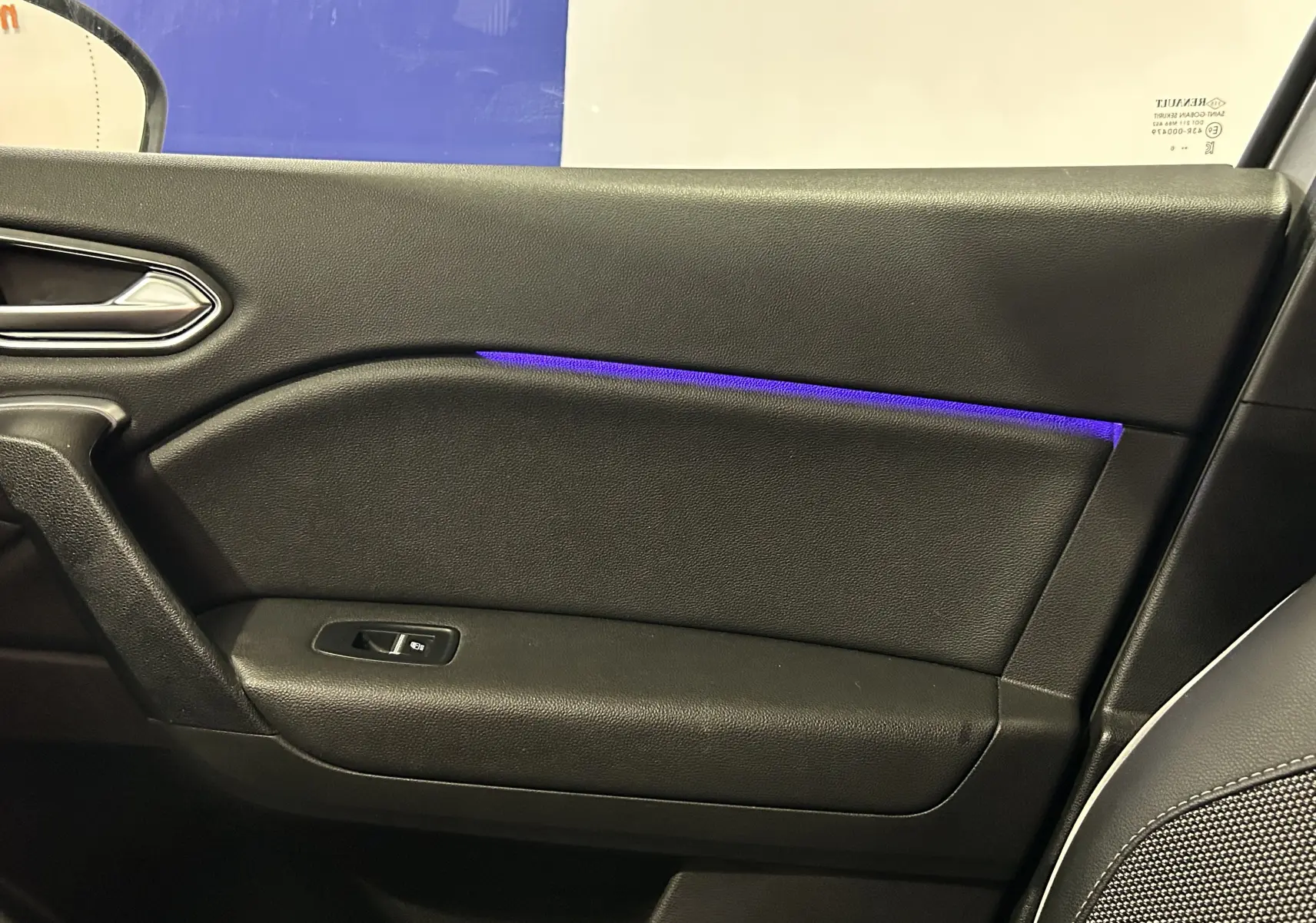 Gros plan sur la porte intérieure côté droit du Renault Captur 2020, avec éclairage d'ambiance bleu et garniture noire.