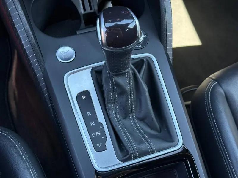 Gros plan sur la commande de boîte automatique et le bouton start/stop de l'Audi Q2 35 TDI S line 2025, intérieur cuir noir.