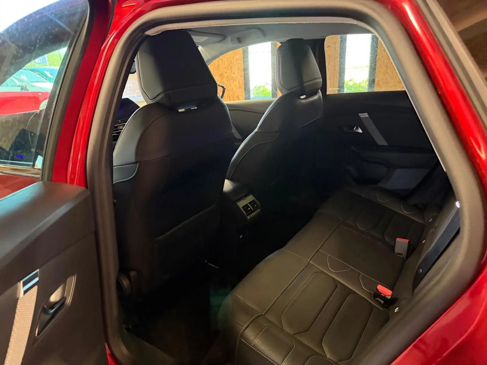Vue intérieure côté gauche sur l'arrière d'une Citroën C4 X rouge de 2021, sièges arrière en tissu noir avec surpiqûres.