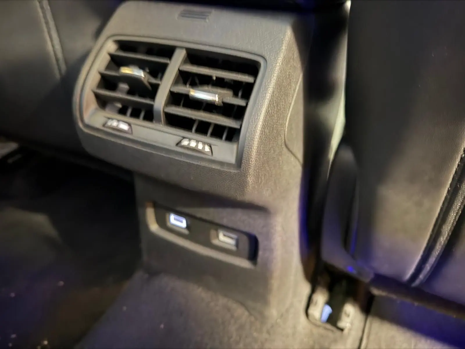 Détail des aérateurs arrière et ports USB lumineux dans l’habitacle noir du Citroën C4 X 2021.