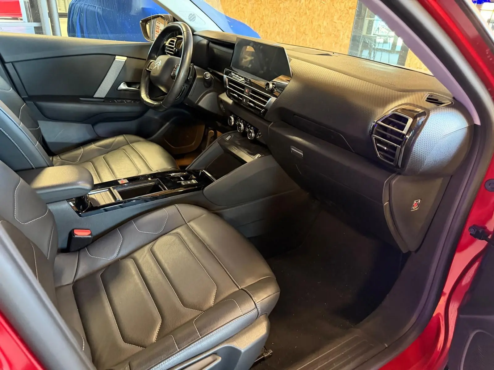 Intérieur noir cuir de la Citroën C4 X 2021, vue côté passager avec tableau de bord moderne et écran tactile central.