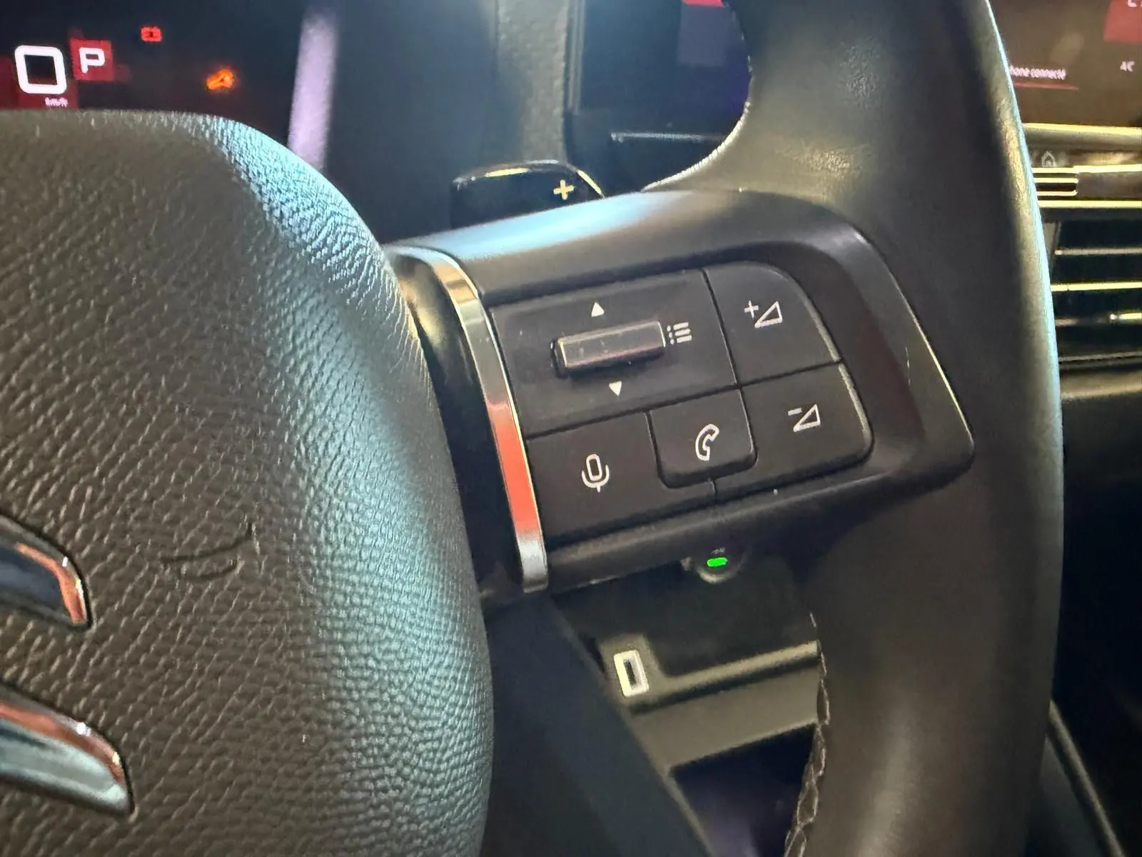 Gros plan sur la partie droite du volant noir de la Citroën C4 X 2021, avec commandes audio et téléphone intégrées.