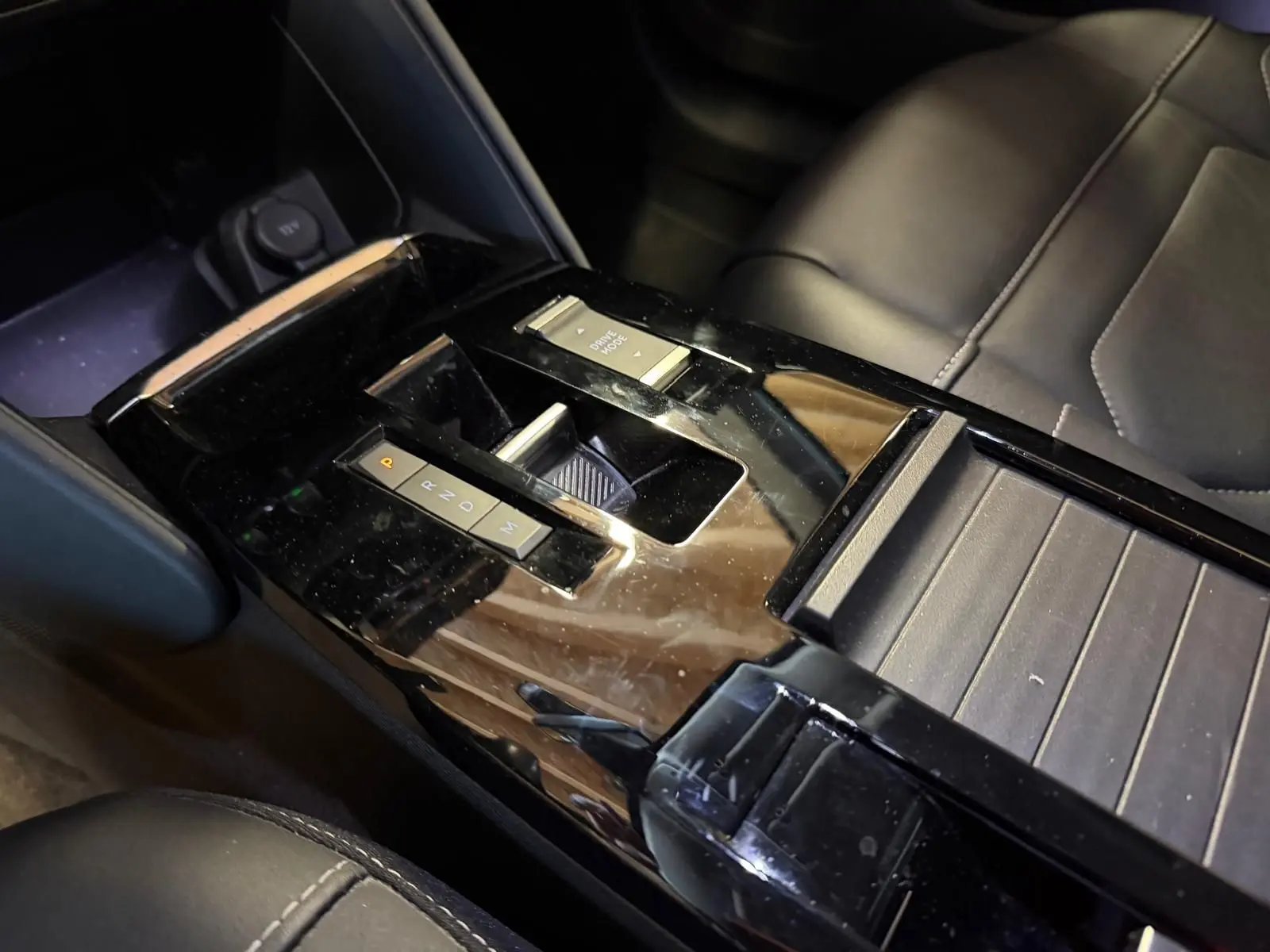 Vue rapprochée de la console centrale noire brillante avec sélecteur de boîte auto et bouton Drive Mode du Citroën C4 X 2021.
