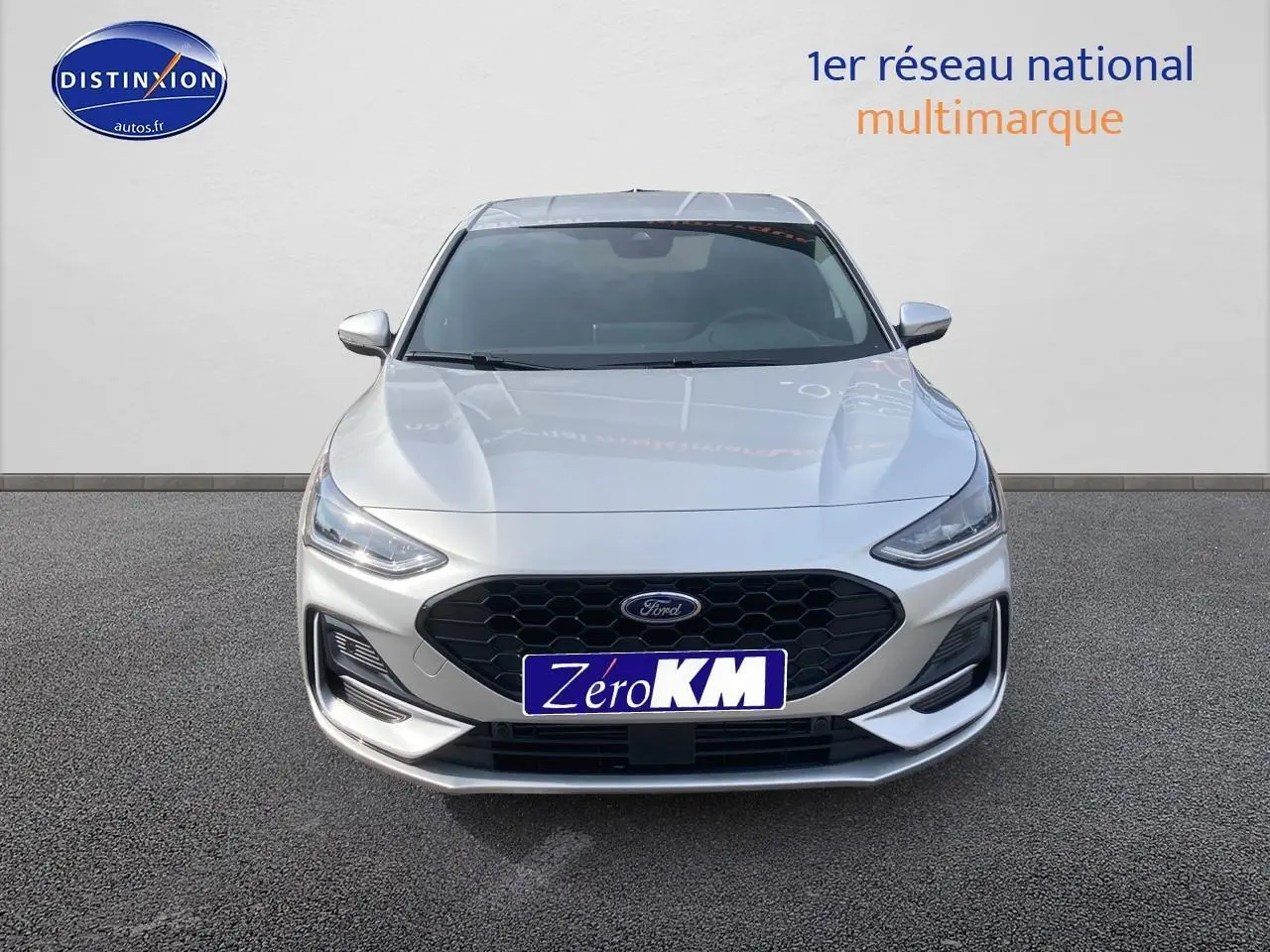 Vue frontale d'une Ford Focus gris clair avec calandre noire hexagonale et feux LED fins.