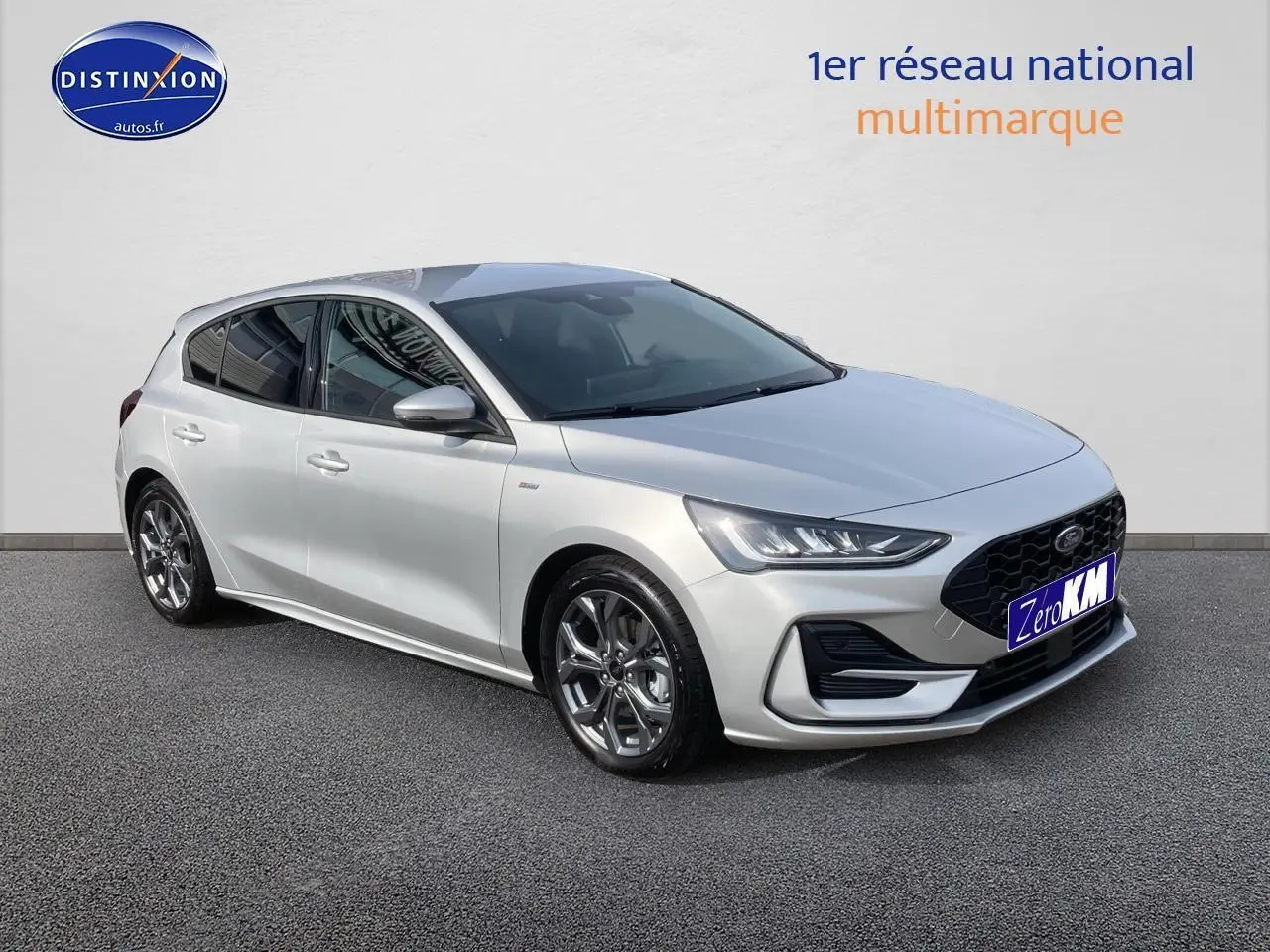 Ford Focus gris clair vue 3/4 avant droit avec jantes alu 17 pouces et calandre noire sportive.
