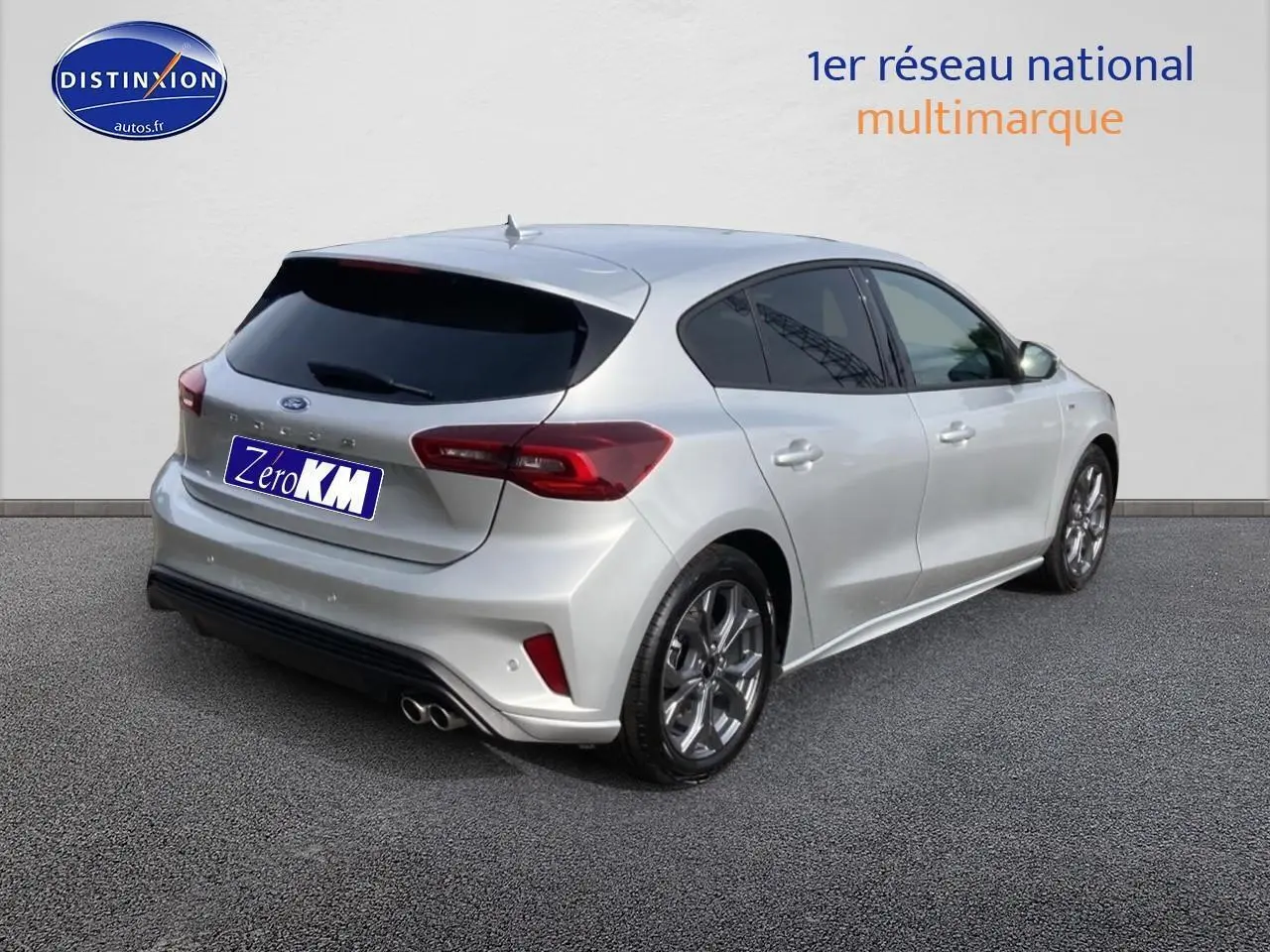 Ford Focus gris vue 3/4 arrière droit avec jantes alu 17 pouces et double sortie d’échappement sport.