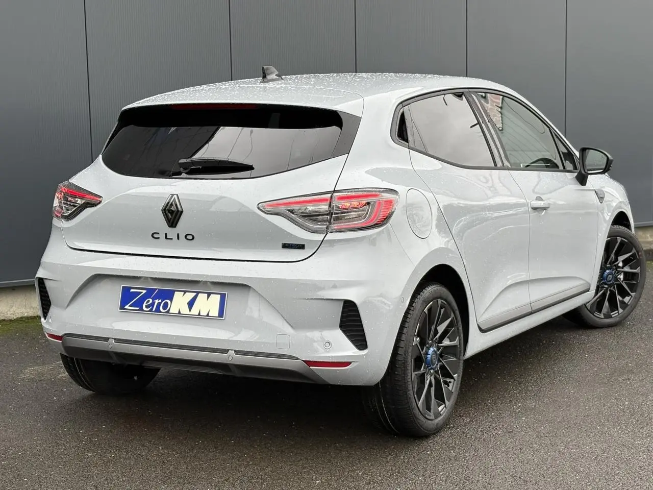 Vue 3/4 arrière droite d'une Renault Clio Gris Rafale avec jantes noires et vitres surteintées.