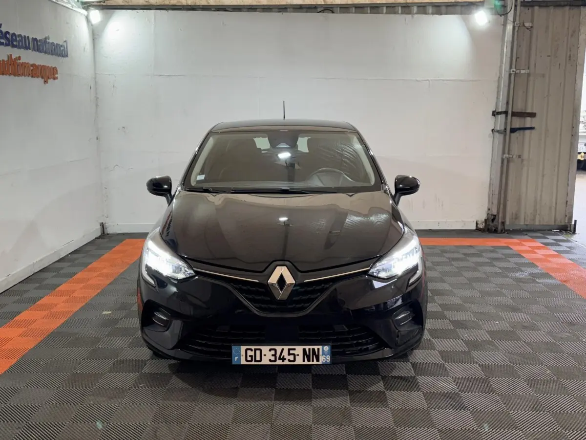 Renault Clio Business E-Tech hybride noire vue de face, phares LED allumés dans un garage.