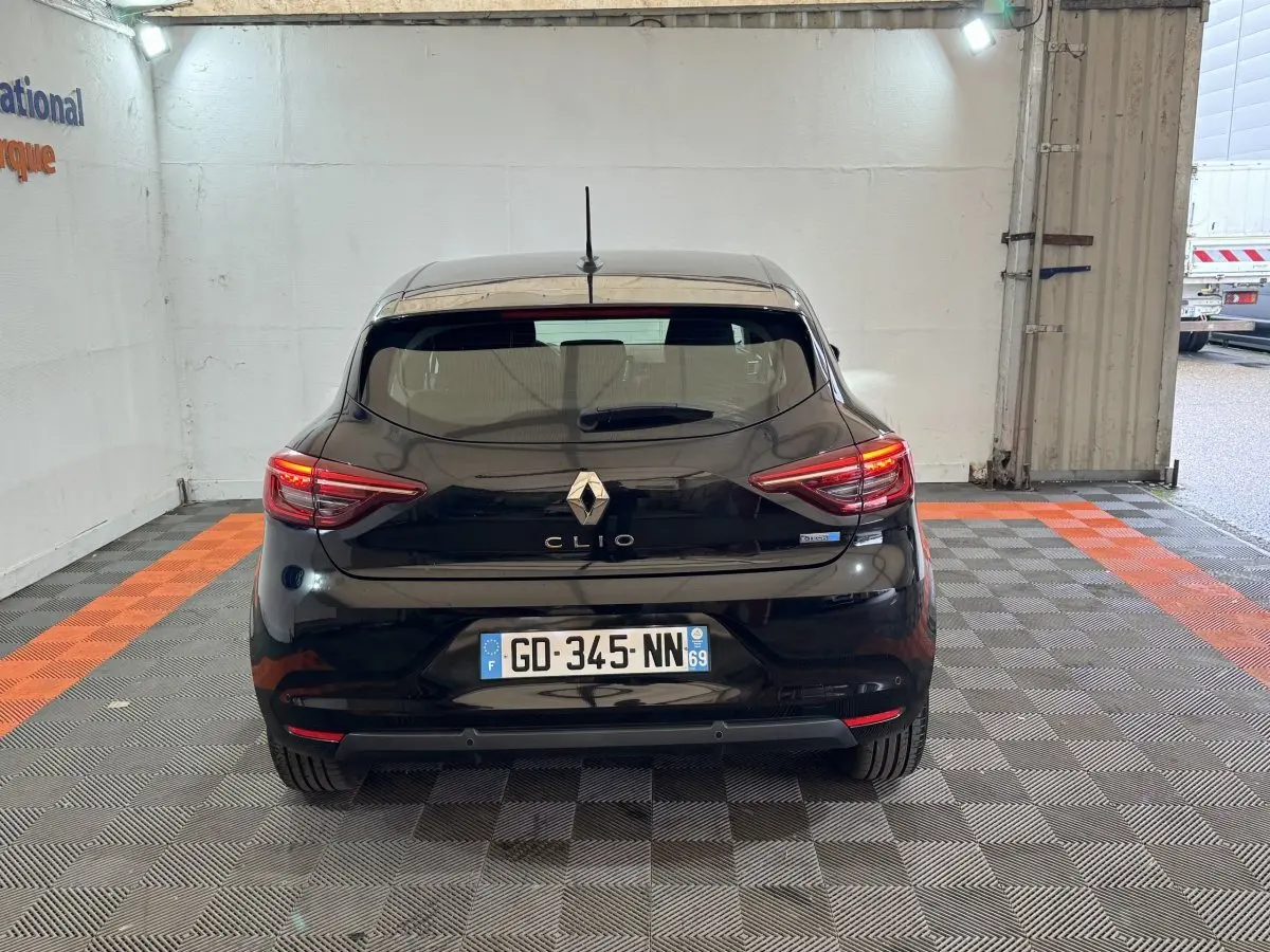 Vue arrière d'une Renault Clio Business E-Tech hybride noire de 2021 avec feux arrière LED allumés.