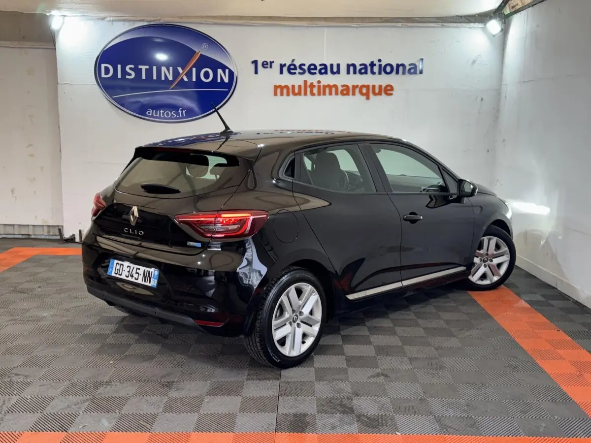 Renault Clio Business E-Tech hybride noir vue 3/4 arrière droit dans un showroom avec sol gris et orange.