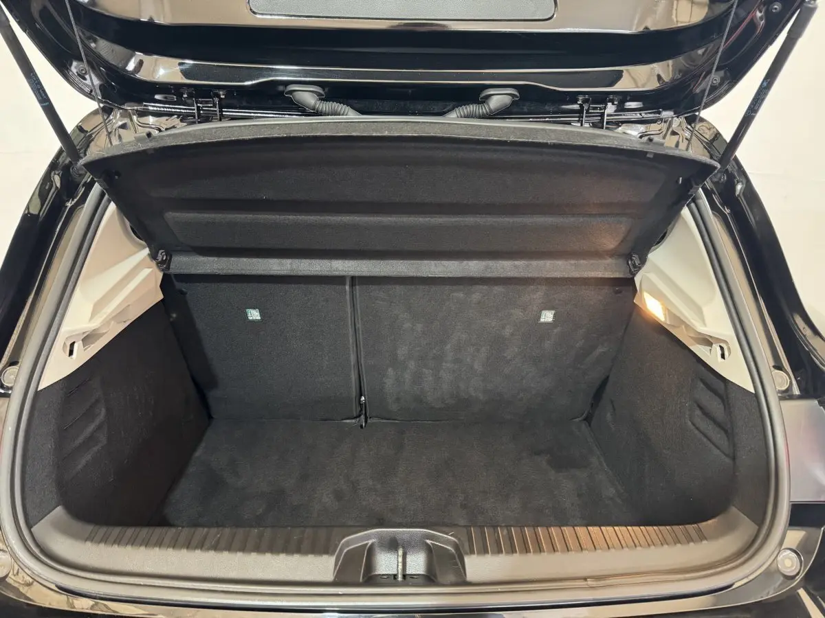 Coffre ouvert de la Renault Clio Business E-Tech hybride noir, vue intérieure arrière montrant la banquette rabattable 2/3-1/3.