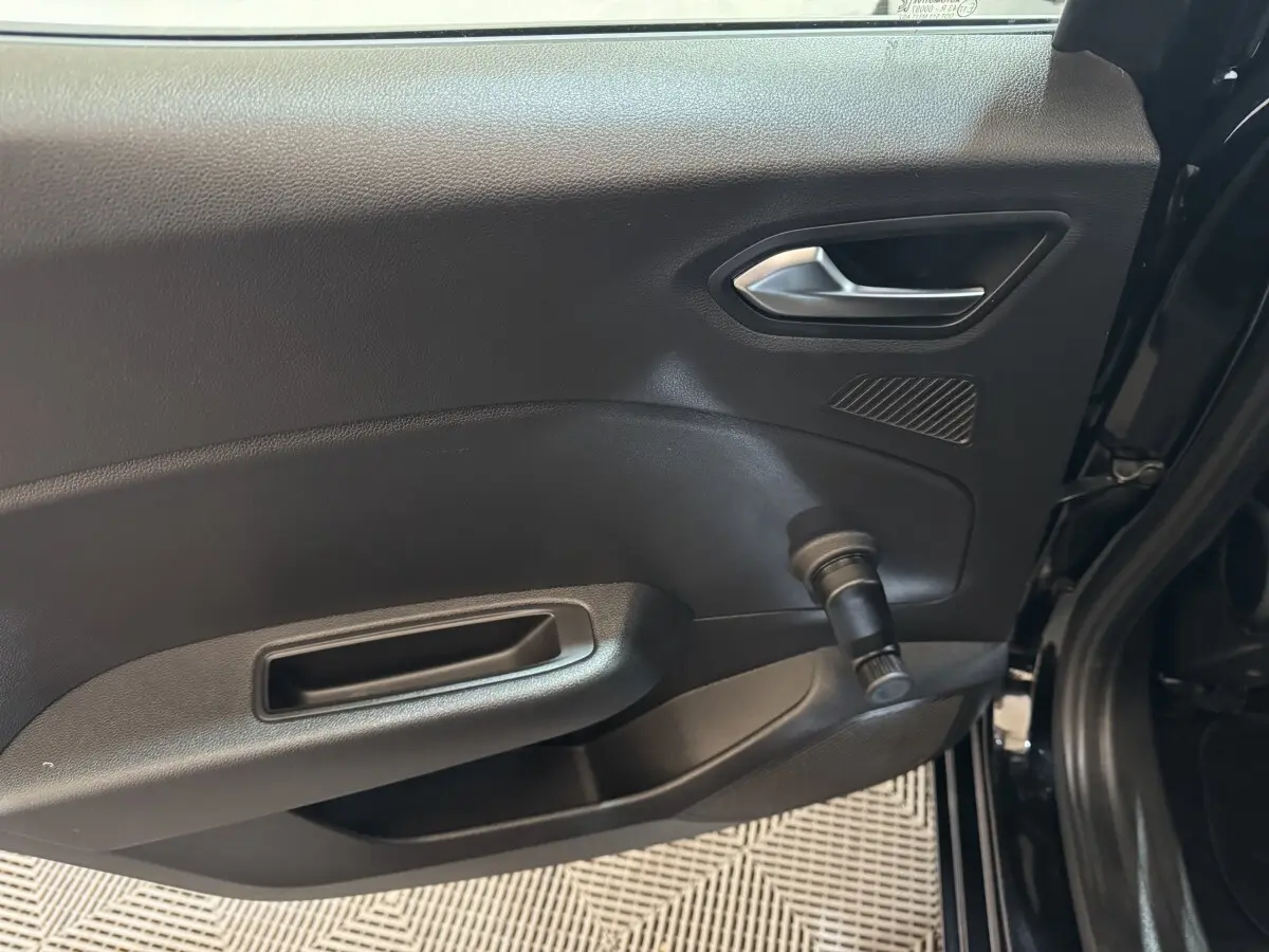 Vue intérieure côté gauche de la porte arrière noire de la Renault Clio Business E-Tech hybride 2021 avec poignée manuelle de vitre.