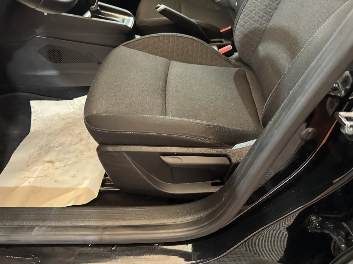 Vue rapprochée du siège avant droit noir en tissu de la Renault Clio Business E-Tech hybride 2021, porte ouverte.