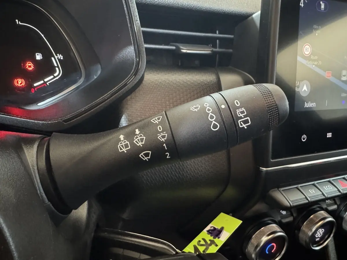 Gros plan sur la commande des essuie-glaces à gauche du volant dans l’habitacle noir de la Renault Clio Business E-Tech hybride 2021.