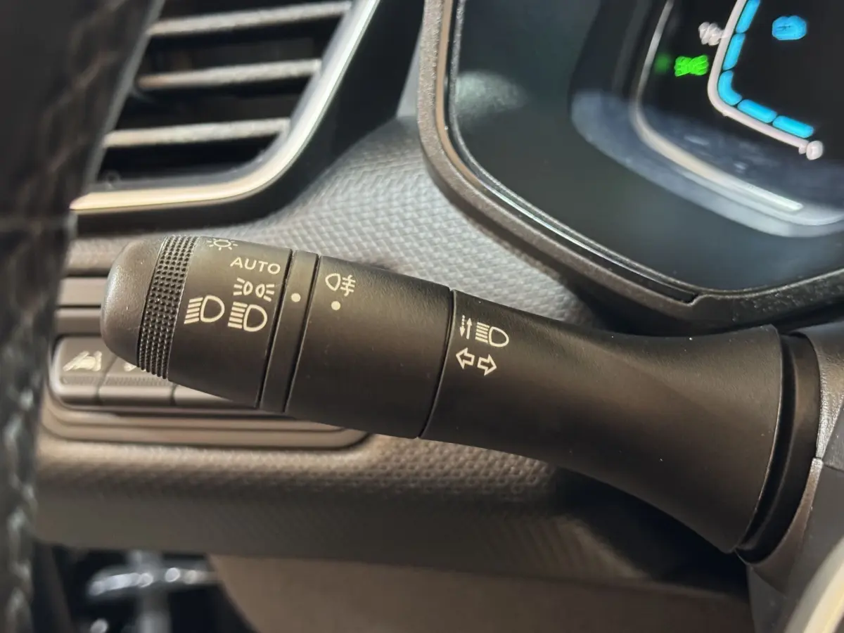 Gros plan sur la commande des phares et clignotants dans l’habitacle noir de la Renault Clio Business E-Tech hybride 2021.