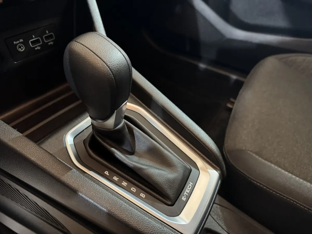 Gros plan sur la commande de boîte automatique noire avec logo E-TECH dans l’habitacle d’une Renault Clio Business hybride.