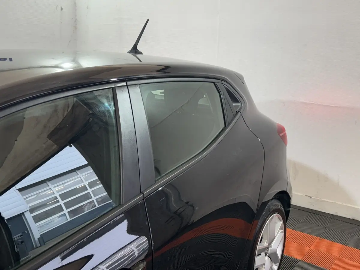 Détail du côté gauche arrière d’une Renault Clio Business E-Tech hybride noire, avec vitre et jante visible.