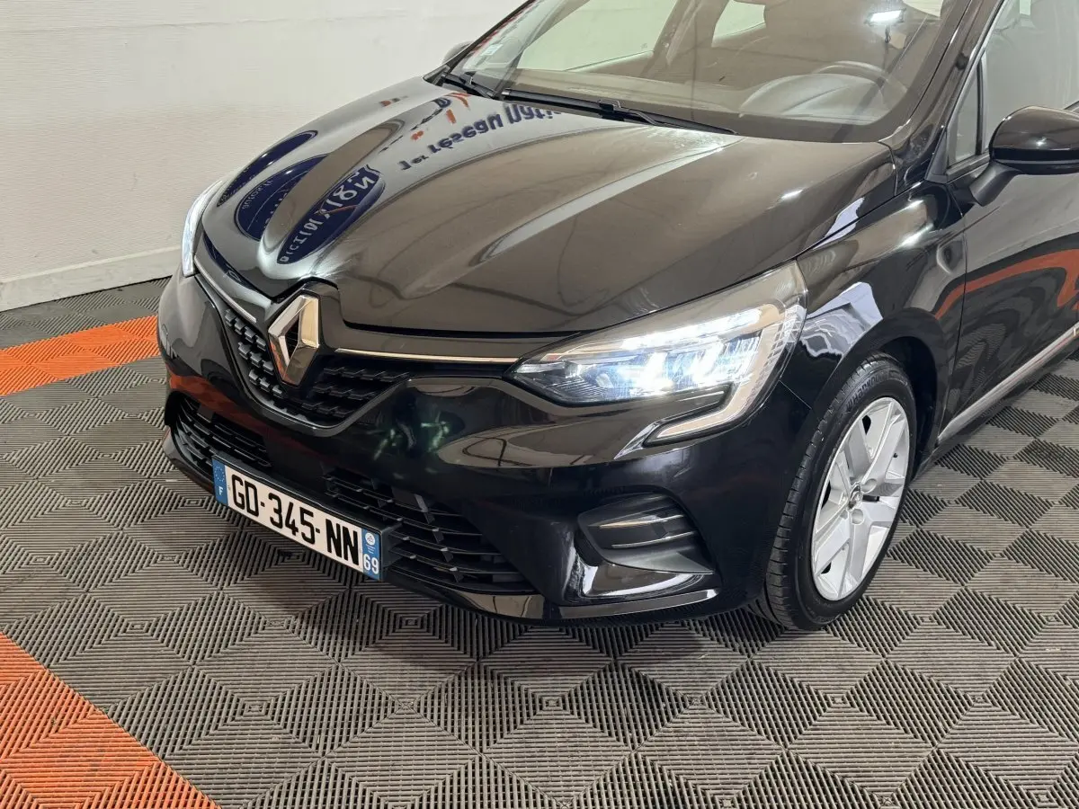 Renault Clio Business E-Tech hybride noir vue 3/4 avant droit avec phares LED allumés et calandre distinctive.