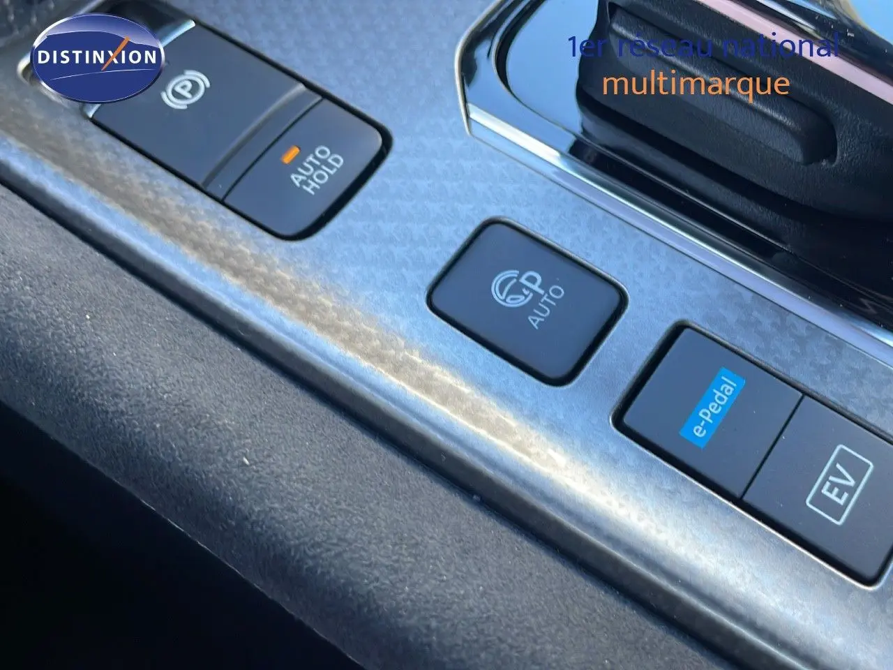 Gros plan sur les commandes de la console centrale du Nissan Qashqai blanc nacré avec finition N-Design, boutons e-Pedal et EV visibles.