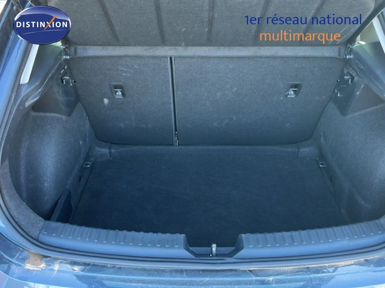 Coffre ouvert vu de l'arrière d'une SEAT LEON 1.5 TSI 115CH DSG Style 25 Anniversaire gris magnétique métal.