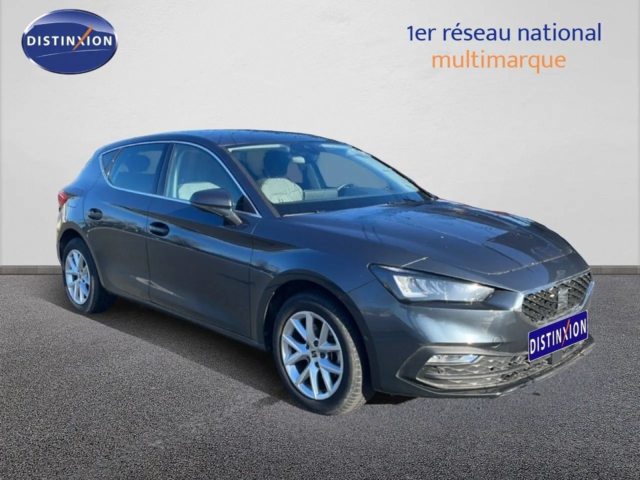 Vue 3/4 avant d'une SEAT Leon 2025 gris magnétique métal avec jantes alliage et calandre distinctive.