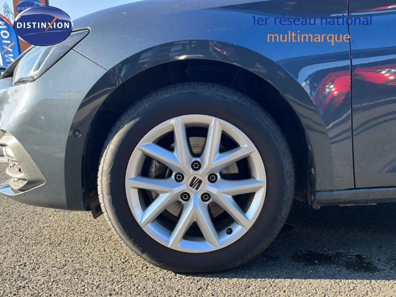 Gros plan sur la roue avant gauche d'une SEAT LEON gris magnétique métal, mettant en valeur la jante alliage distinctive.