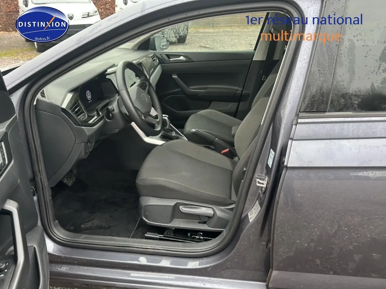 Vue intérieure côté conducteur de la Volkswagen Polo gris cendre 2025, montrant sièges et tableau de bord moderne.