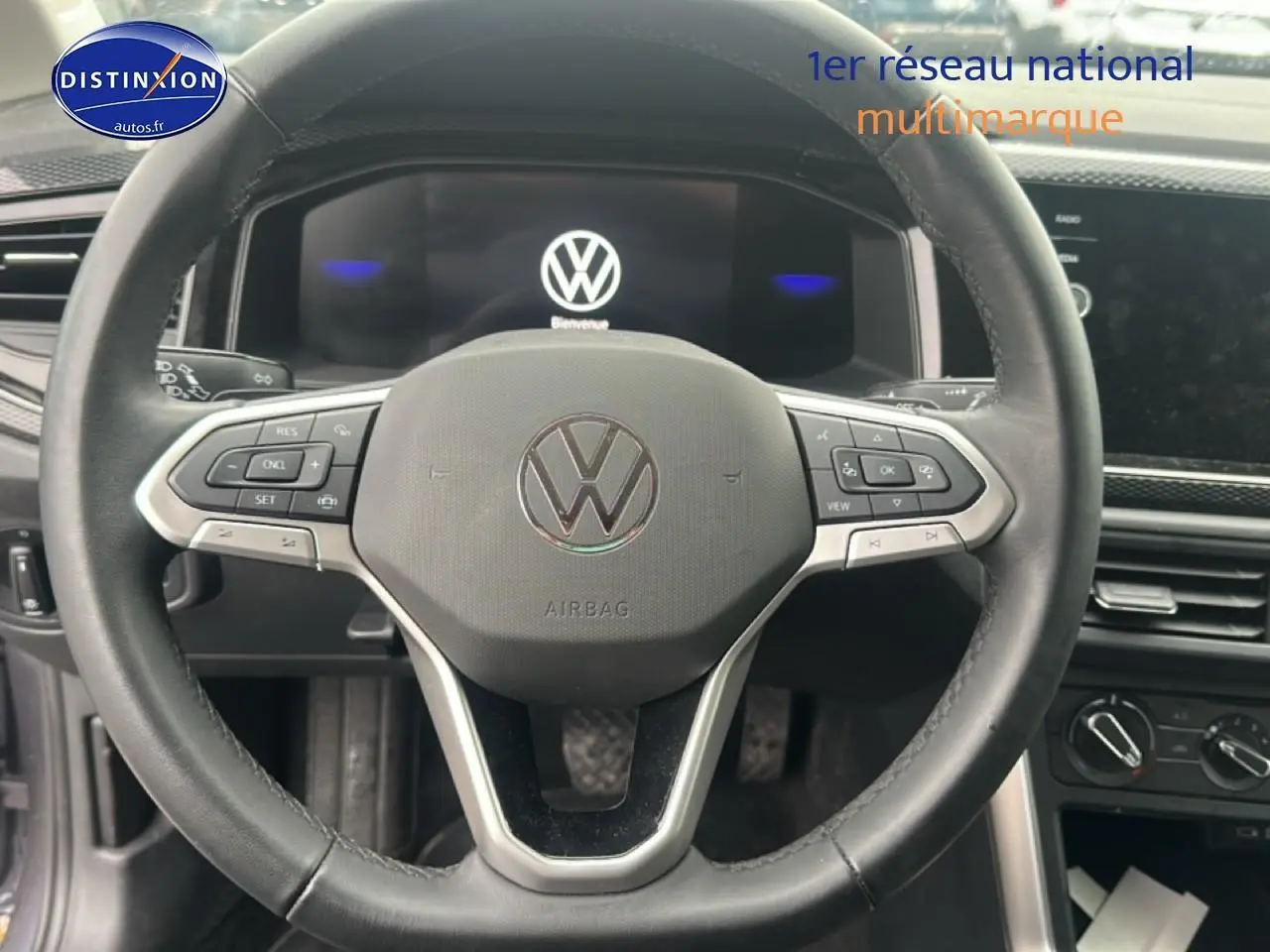 Vue rapprochée du volant cuir multifonction d'une Volkswagen Polo 2025, avec tableau de bord digital et commandes intégrées.