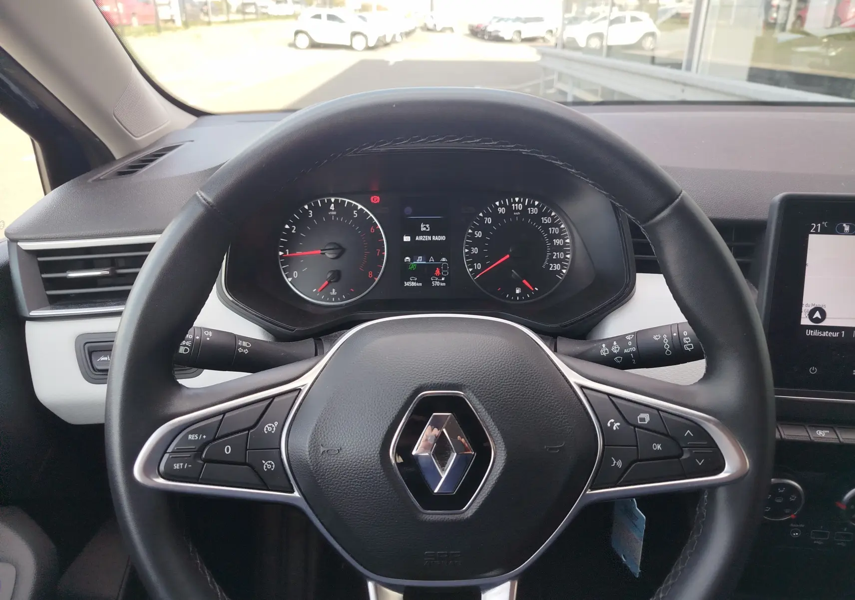 Vue centrée sur le volant noir de la Renault Clio 2022 avec tableau de bord et commandes au volant visibles.