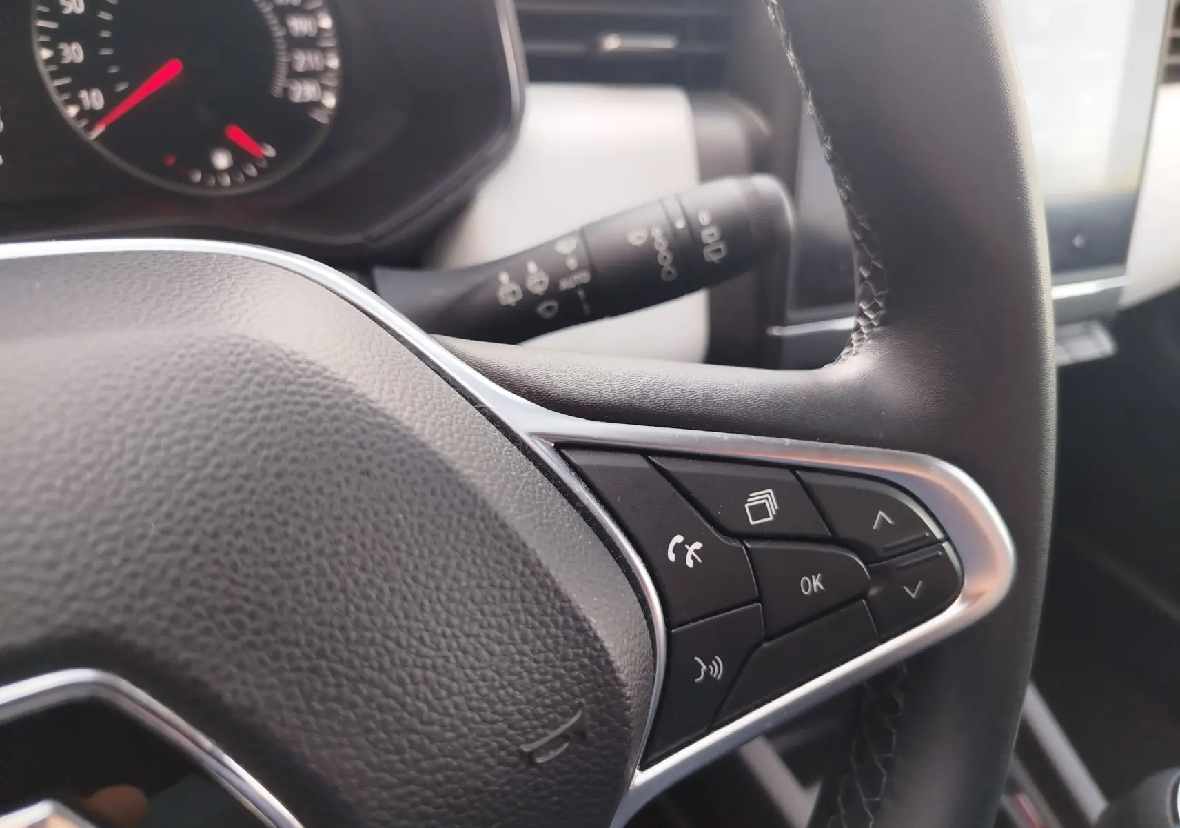 Gros plan sur le volant côté droit de la Renault Clio 1.0 SCe 65ch Evolution 2022 avec commandes multifonctions et finition noire.