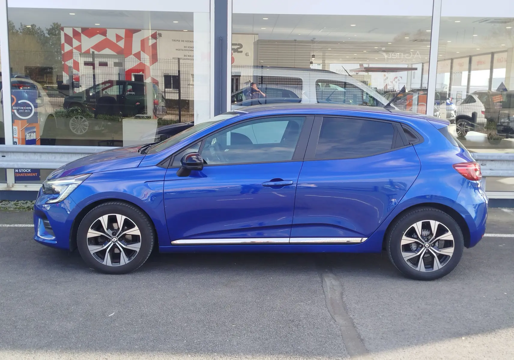 Profil latéral droit d'une Renault Clio 1.0 SCe 65ch Evolution bleu Iron avec jantes alliage et vitres teintées.