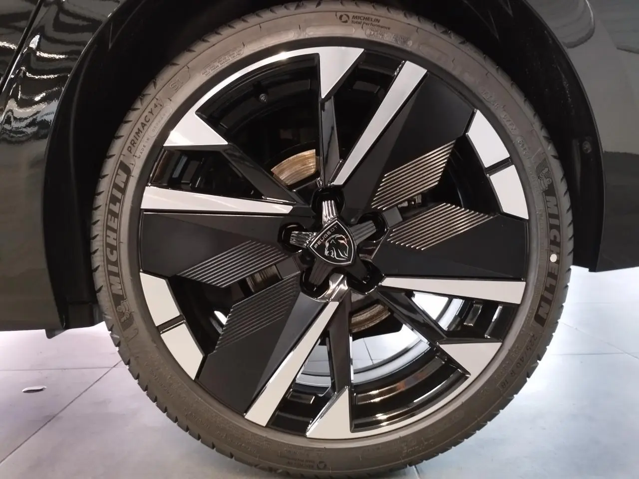 Gros plan sur la jante alliage 18" bi-ton noir et argent du Peugeot 308 noir métal, avec logo lion central.